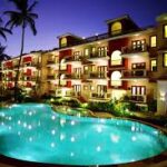 all things travel image of a hotel at night showing the pool right in front of the building
