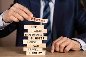insurance an image of a man stacking blocks labeled with different insurances on each one  
