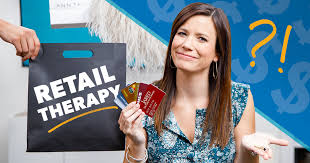 retail therapy image with a lady holding many credit cards on her hand and a great big smile on her face. With a bag with the words retail therapy and a ? ! marks